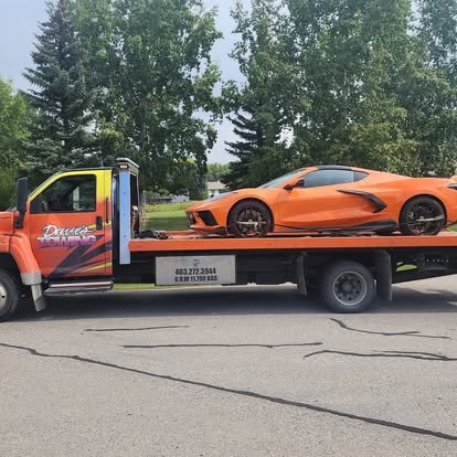 Dave's Towing flatbed truck towing a sports car in Okotoks